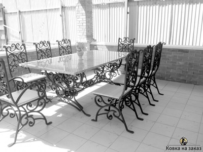 Большой кованый стол с&nbsp;белой мраморной столешницей и&nbsp;набор ажурных стульев