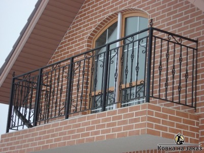 Кованое ограждение для балкончика второго этажа с корзинками и S-образными коваными элементами