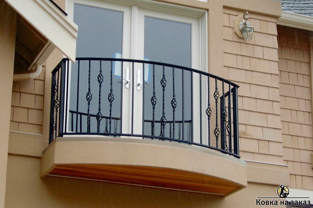Традиционные кованые перила на балкон с металлическим поручнем выполнены в виде чередующихся сварных и крученых кованых стоек