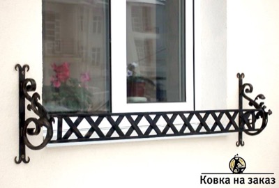 Кованая цветочница под окно с решетчаткой стенкой и украшенными вензелями и листьями кронштейнами