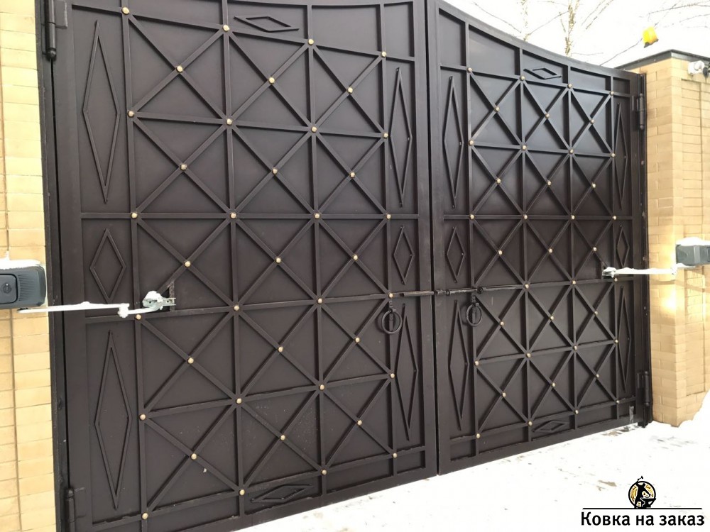 Распашные кованые ворота полностью закрыты листом и&nbsp;симметричным двухсторонним геометрическим рисунком