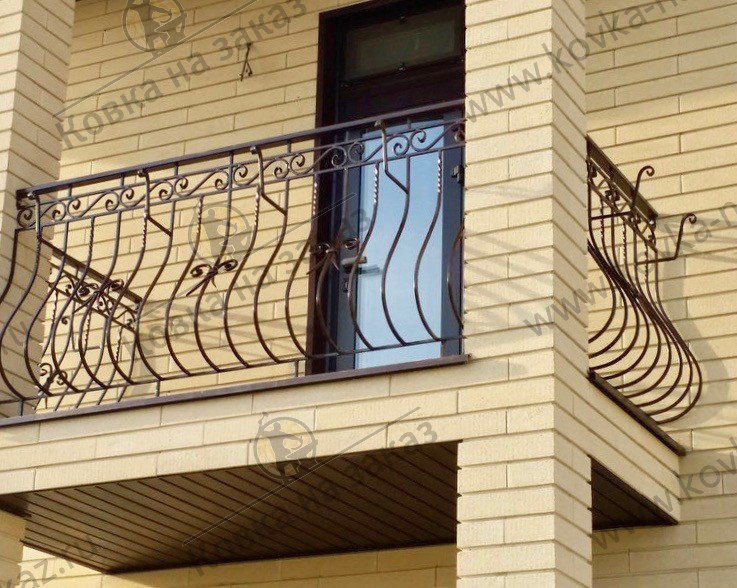 Традиционное кованое ограждение для балкона в виде «пузатых» перил с небольшим украшением из кованых элементов