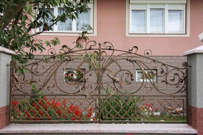 Кованый забор с&nbsp;металлической сеткой и&nbsp;большими декоративными листьями
