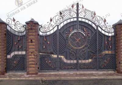 Монументальные кованые ворота с калиткой украшены плотным сетчатым узором и коваными завитками с большими листьями